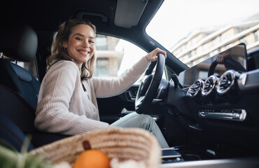 Happy woman driving her new electric car.