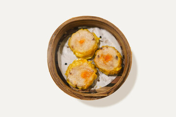 Delicious steamed dumpling dimsum or siomay on bamboo steams isolated on white background. dimsum or dumpling is a snack from China and Hong Kong is made from chicken, pork, shrimp.