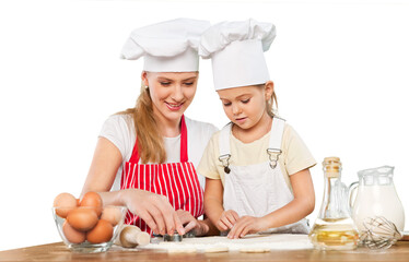 Mother and little girl making a cake together - spreading the filling