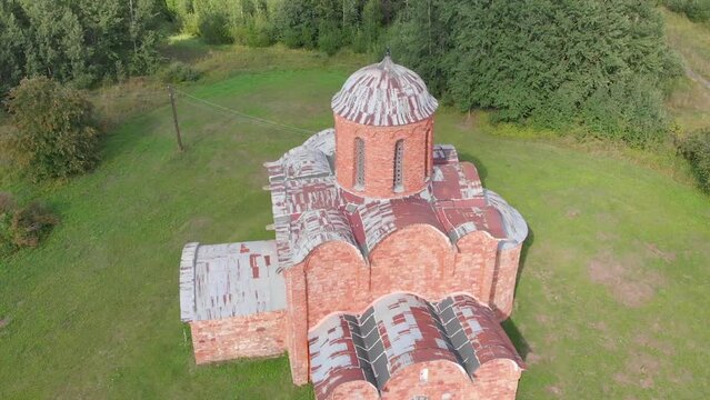 The old Orthodox Church of the Savior on Kovalev on the outskirts of Veliky Novgorod. The view from the drone on a sunny day.