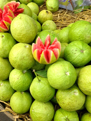 A stack of guava fruits with a sliced piece. 