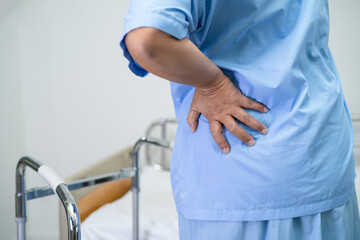 Asian lady patient use walker in hospital to support walking.