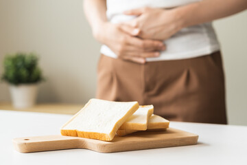 Gluten allergy, asian young woman hand push out, refusing to eat white bread slice on chopping...