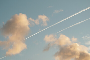 Naklejka na ściany i meble Jet line tracks on the sky with colorful clouds