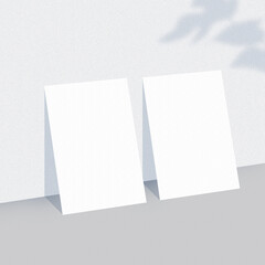 Two empty white paper sheets on light background with shadow overlay. The papers mock-up.