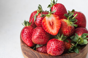 Ripe juicy strawberries in a wooden bowl