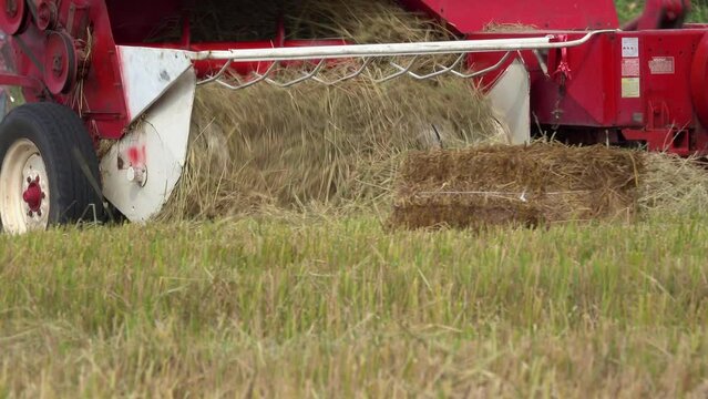 Close-up hay balers working in the rice field