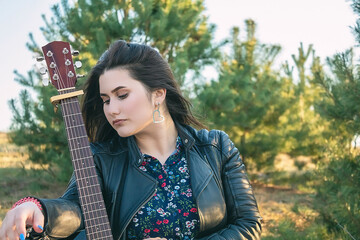 Girl with a guitar. Music in the nature. Have a nice vacation