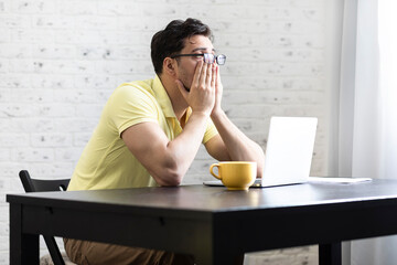 Stressed man working on laptop at home. Distance work concept	