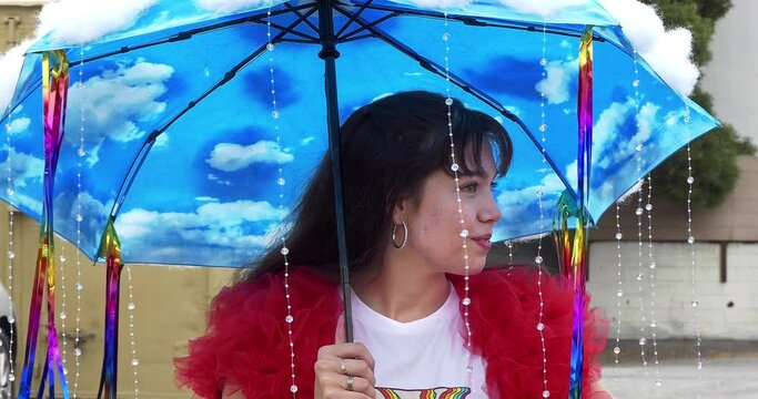 Young girl with umbrella smiling at the annual LGBT gay and lesbian Pride Parade in West Hollywood, Los Angeles, California, 4K