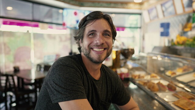 Happy Man Posing For Camera While Ordering Food At Restaurant Diner. Joyful Male Person Smiles While Placing Lunch Order To Go