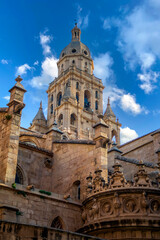 Fototapeta na wymiar Vertical view of the south façade of the Cathedral of Santa Maria in Murcia, Spain with recognizable Renaissance and Gothic styles and the bell tower in the background