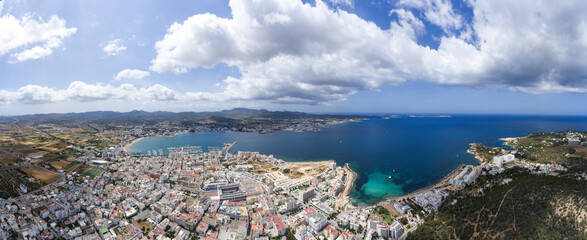 Fototapeta premium Wide angle large aerial photo of the beautiful town of Sant Antoni de Portmany in Ibiza Spain showing the whole of the town and ocean beach front in the summer time.