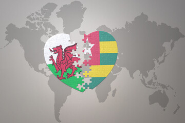 puzzle heart with the national flag of togo and wales on a world map background.Concept.