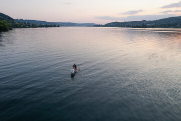 Fototapeta na wymiar aerial footage of people kayak during sunset in the lake in Switzerland