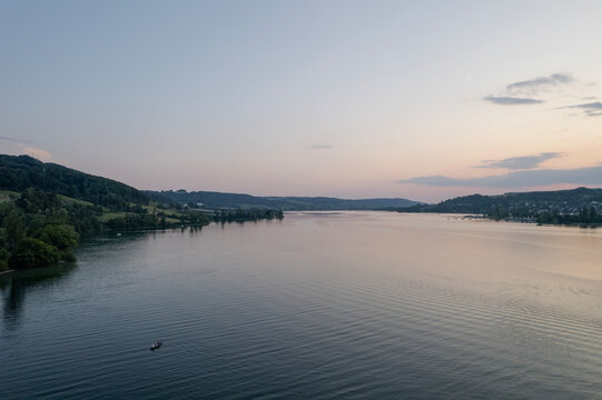 aerial footage of sunset over the lake in switzerland and a kayak in the wayer