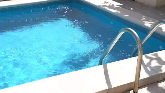 Grab bars ladder in the blue swimming pool