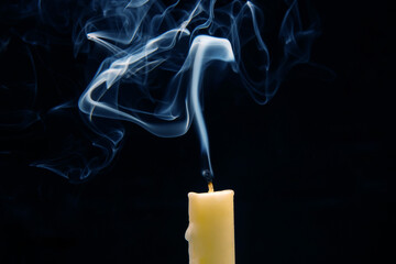 Smoke from an extinguished candle on a dark background. The concept of spirituality and the end of...