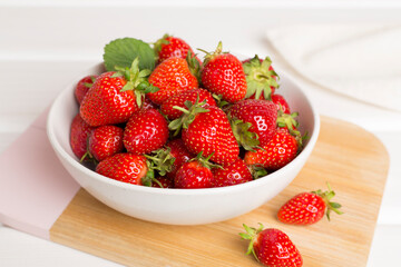 Fresh strawberries in bowl on wooden table