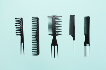 Professional combs and hairdresser tools on color background, top view