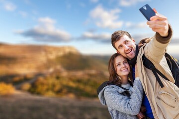 Naklejka premium Young happy couple traveler using phone for taking selfie