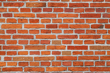 Naklejka premium Texture of an old damaged orange brick wall as an architectural background