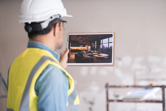 Architect holding picture of project design with modern loft-style interior man in hardhat and vest inspecting premise and imagining living room after renovation