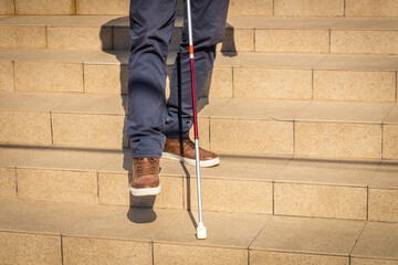 a blind person tries to go down the stairs helping himself with a cane, Disability problems, Concept, Ease of access, strategy for equality for people with disabilities