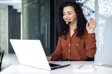 Video call online meeting with colleagues, Hispanic woman working inside modern office,...
