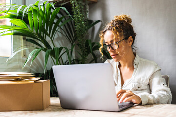 Professional freelance businesswoman working at home office with laptop and wearing glasses....
