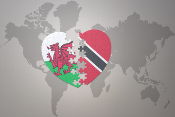 puzzle heart with the national flag of trinidad and tobago and wales on a world map background.Concept.