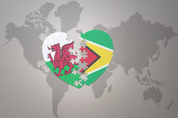 puzzle heart with the national flag of guyana and wales on a world map background.Concept.