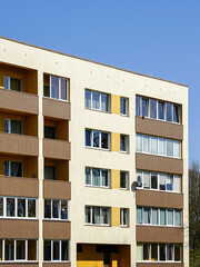 Obraz premium Renovated and insulated multistorey apartment building facade fragment against a blue sky background