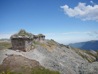 Fototapeta premium Marcahuasi chullpas, house made with stones on the top of the mountain, archaeological remains in the mountains with a background of blue sky with clouds in South America