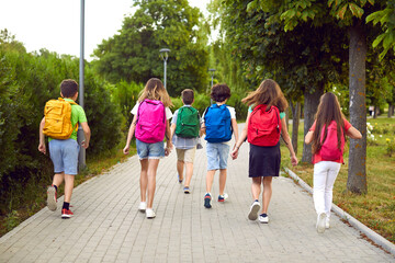 Group of kids on their way to school. Several children going to class together. Six male and female...