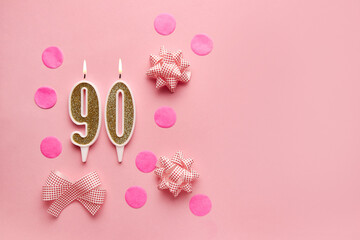 Number 90 on pastel pink background with festive decor. Happy birthday candles. The concept of celebrating a birthday, anniversary, important date, holiday. Copy space. banner