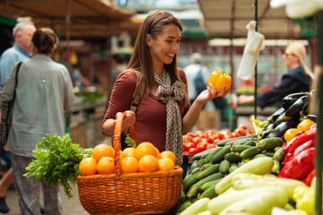 Young woman buying fruit in farmers market stall - obrazy, fototapety, plakaty