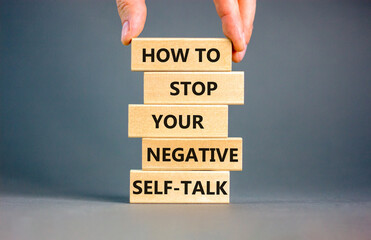 Stop negative self-talk symbol. Concept words How to stop your negative self-talk on wooden block. Psychologist hand. Beautiful grey background. Psychological negative self-talk concept. Copy space