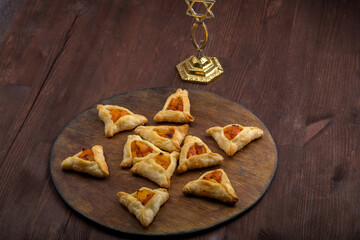 Sweet gomentashi cookies for the Jewish holiday of Purim on a chalkboard are laid out in the form of Magen David on the table.