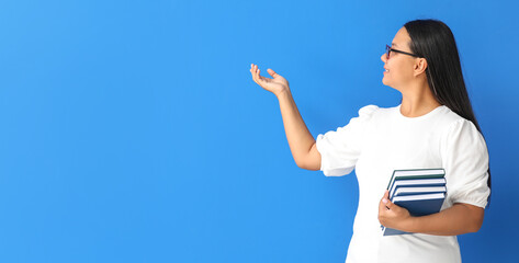 Asian female teacher on blue background with space for text