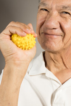Mature man holding and squeezing massage therapy spike balls 