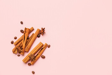 Cinnamon sticks, anise stars and coffee beans on pink background