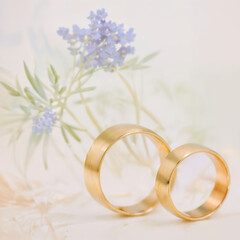 Obraz na płótnie Canvas Wedding rings with lavender flowers background. Wedding bands banner, website header, wedding invitation. Generative AI.