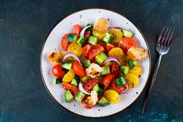 Vegetarian salad Panzanella with tomatoes, onion and bread Croutons. Dark background. Top view. Italian salad