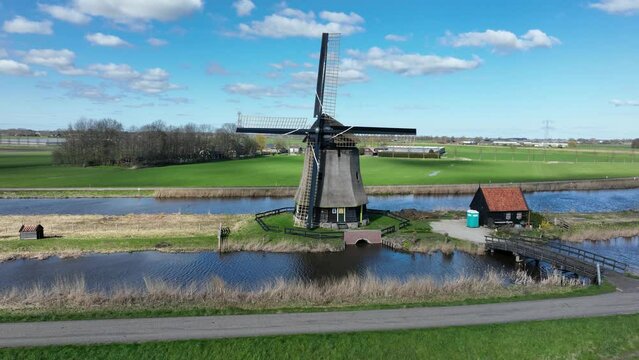 Embark on a journey through time as you witness the historic windmills, a testament to the Netherlands' agricultural past, set against a sky painted with fluffy clouds.