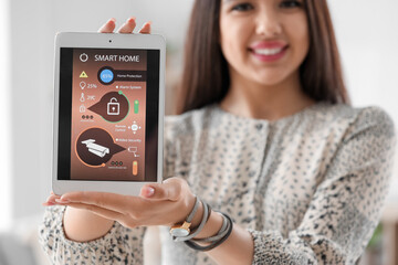 Young woman with smart home security system control panel, closeup