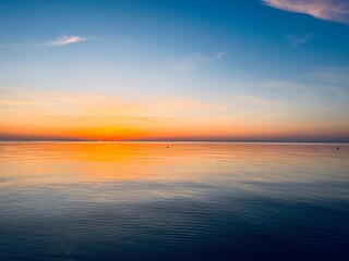 Orange sea horizon, evening seascape background, natural colors, calm water surface reflection
