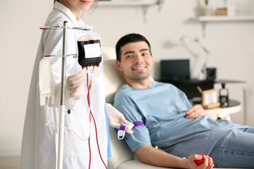 Female doctor taking blood from young donor in clinic