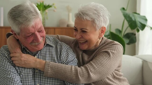 Senior adult mature couple hugging at home. Mid age old husband and wife embracing with tenderness love enjoying sweet bonding wellbeing. Grandmother grandfather together. Family moment love and care
