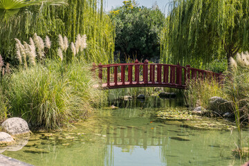 old wooden arch bridge in japanese zen garden